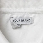 YOUR BRAND woven neck label close-up on a white polo shirt - private label detail - SiATEX Sourcing